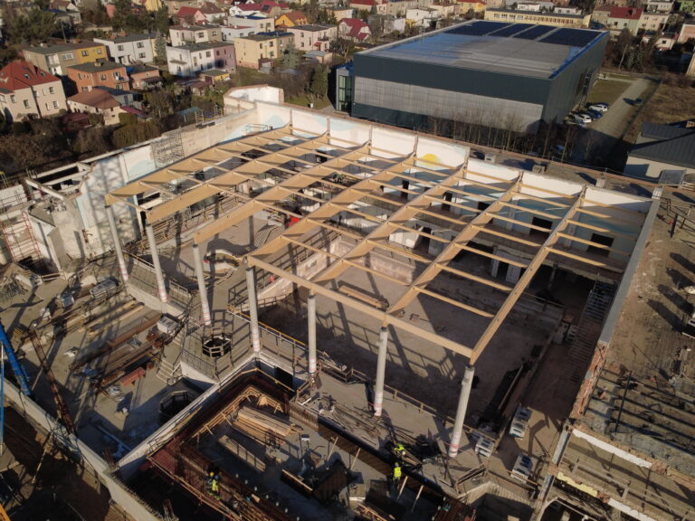 Ujęcie lotnicze prezentujące drewnianą konstrukcję dachu.